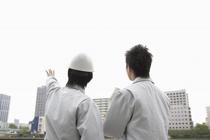 談笑する作業服の男性二人